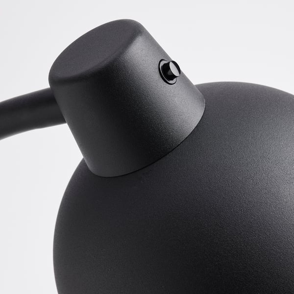 Närbild av modern svart lampa. Strukturerad, robust design. Flexibla leder för justeringar. Solid metallkonstruktion.