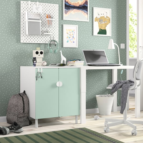 Litet hemmakontor med SMÅSTAD ljusgrönt skåp, vitt skrivbord, modern inredning, minimalistisk design, passar bra i mysigt utrymme.