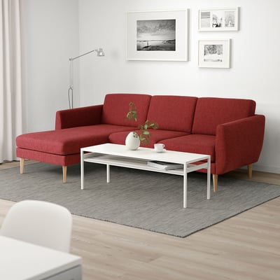 Mysigt vardagsrum med röd SMEDSTORP soffa, vitt soffbord och minimalistisk inredning.