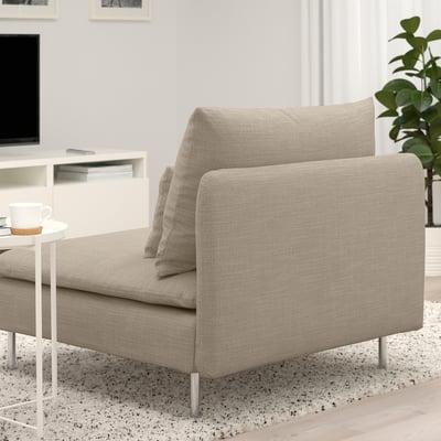 Modern neutral soffa med lösa ryggkuddar, höga ben och smala linjer, perfekt för mysig avkoppling.