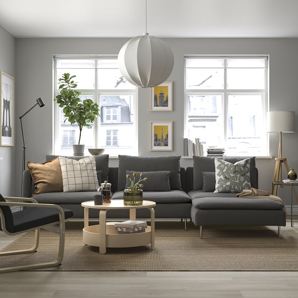 Modernt vardagsrum med stor grå sektionssoffa SÖDERHAMN, soffbord i trä och elegant inredning, med stora fönster och en rund matta.