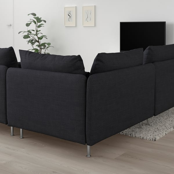 Mörkgrå SÖDERHAMN sektionssoffa med stilren design, placerad i ett modernt minimalistiskt rum med växter, tv och konstverk.