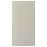 En beige STENSUND skåpdörr med räfflade paneler. Den eleganta, rektangulära designen ger en slät, fläckbeständig yta.