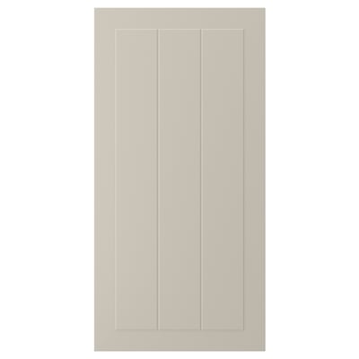 En beige STENSUND skåpdörr med räfflade paneler. Den eleganta, rektangulära designen ger en slät, fläckbeständig yta.