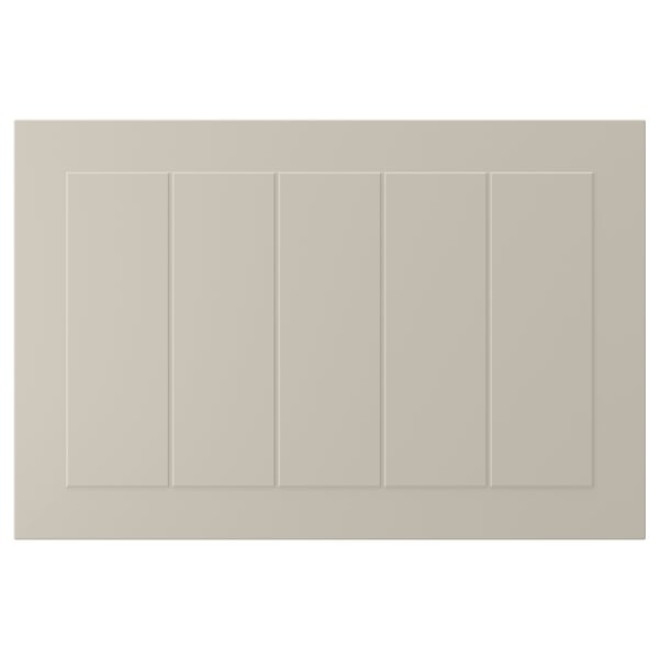 En beige STENSUND skåpdörr med räfflade paneler och en slät, lackerad yta.