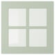 Ett ljusgrönt, kvadratiskt fönster med fyra paneler och en träram.
