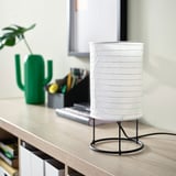 Vit STRANDAD bordslampa med rispappersskärm bredvid grön kaktus på skrivbordet.