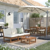 Mysig uteplats med träsoffa, soffbord och beige parasoll.