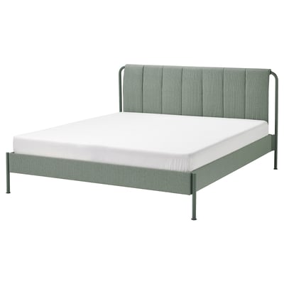 Modern grågrön säng, elegant tyg och metall, rektangulär, vadderad sänggavel.