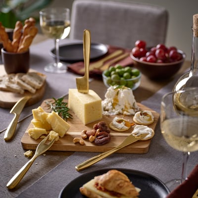 Ostbricka med TILLAGD bestick, vin och frukt.