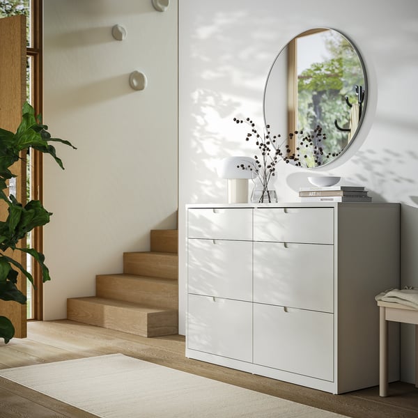 Modern vit TONSTAD byrå, eleganta lådor, snygga handtag, snygg inredning, grå matta, minimalistisk inredning, stor rund spegel.