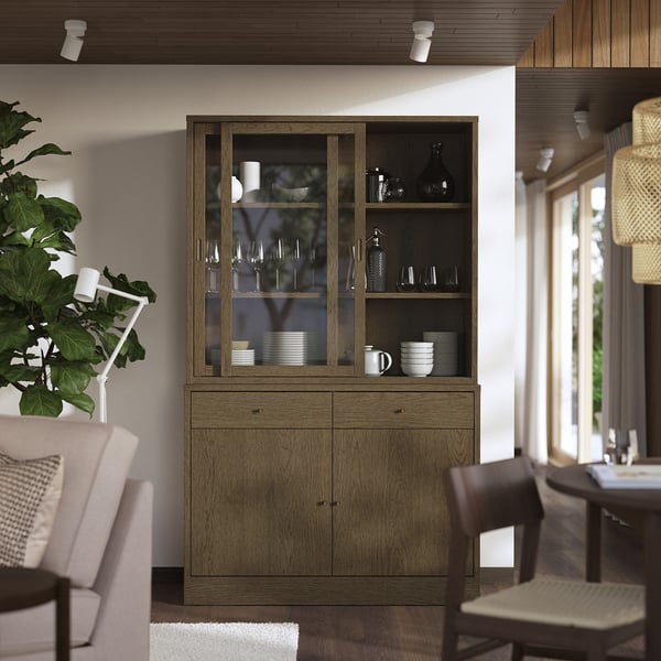 Sideboard TONSTAD i trä med vitrinskåp, displaytallrikar, placerade mellan matstolar.
