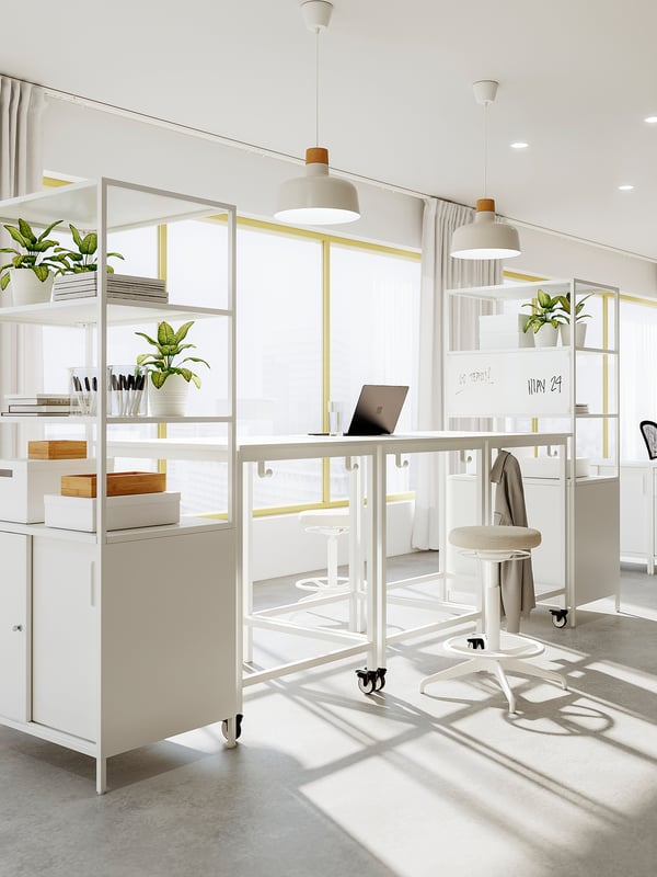 Modern vit arbetsplats med skåpet TROTTEN, stegpall, krukväxter och pendellampor med en elegant design och gott om förvaring.