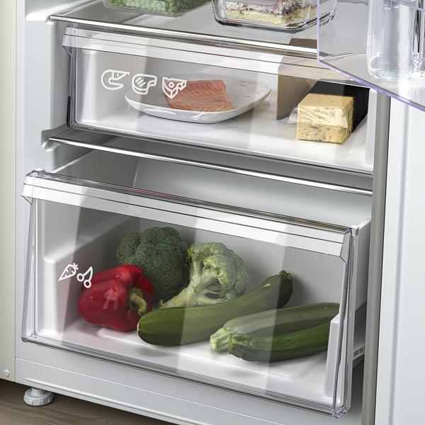 Kylskåp med justerbara hyllor, synliga lådor, grönsaker inuti.