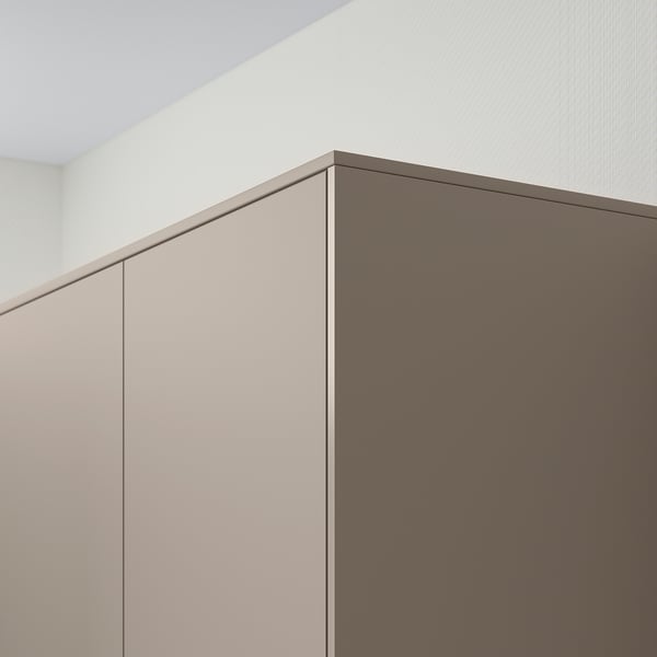 Modernt kök med beige, minimalistiska skåp och dold belysning.