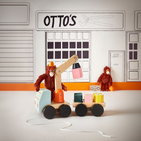 Trälastbil, apkran, block och minimalistisk byggnad med otto-skylten.