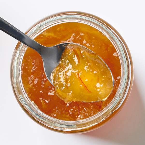 Burk med VAGGSÅNG orange fläderblomsspridning, ljus orange färg, glasburk med sked.