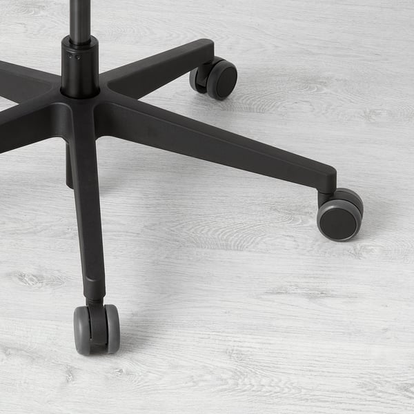 Svart kontorsstolsbas med fem hjul på trägolv. Robust, justerbar design för stabilitet och enkel rörelse.