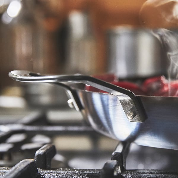 Närbild av det robusta kastrullhandtaget i kolstål, designat för enkel lyftning och värmebeständig användning på alla spishällar, inklusive induktion.