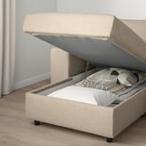 Soffa med förvaring. Schäslongsektionen lyfts upp och avslöjar filtar och kuddar inuti.