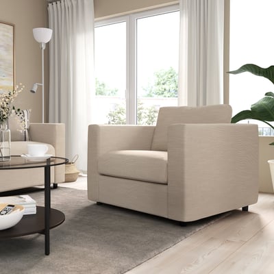 Modernt vardagsrum i neutrala toner med beige VIMLE soffa, fåtölj och soffbord. Mjukt naturligt ljus från stort fönster.