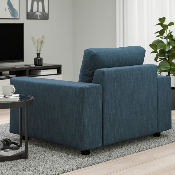 Blå tygsoffa i vardagsrum med trägolv och soffbord.