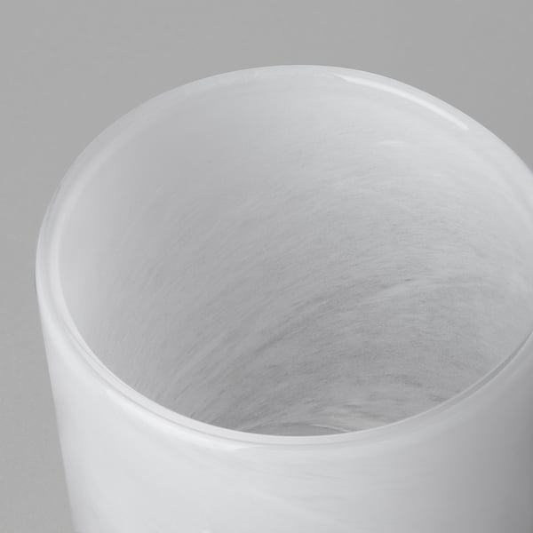 Cylindrisk glasvas med slät, blank yta. Intrikat, virvlande mönster inuti, som återspeglar kvalitetshantverk.