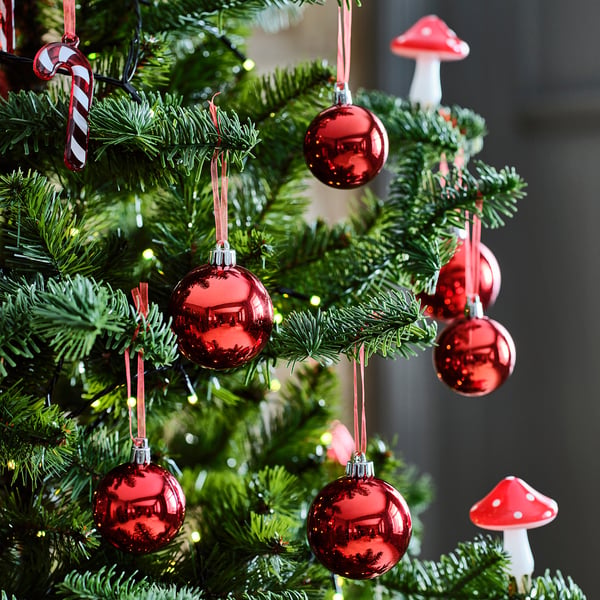 Julgranen dekorerades med glänsande röda kulor och svampprydnader.