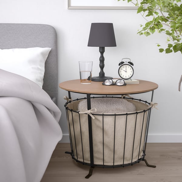 Petite table de chevet avec rangement, design rustique, pieds noirs, plateau en bois, sac en tissu pour le rangement.