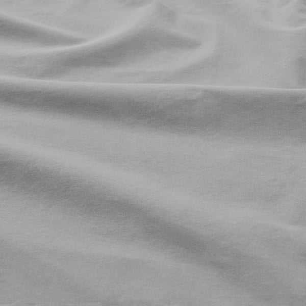 Tissu de coton doux et texturé en gros plan. Tissage visible et ombres douces, mettant en valeur la qualité et le confort.