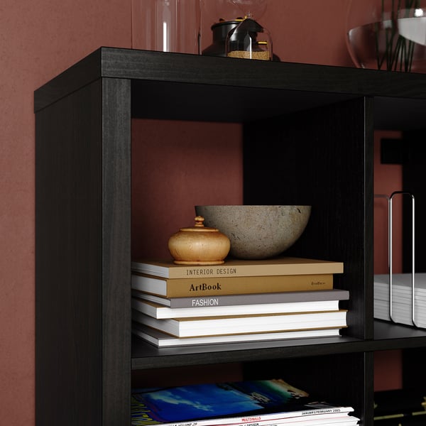 Étagère noire avec livres, vases et bol décoratif. Décoration intérieure moderne, minimale et élégante.