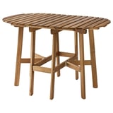 Une table d’extérieur en bois ASKHOLMEN en marron. Il est rond avec des abattants repliables et des pieds robustes en bois d’acacia.