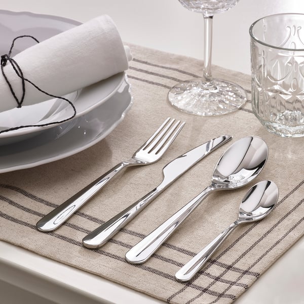 Couverts élégants posés sur une table. Comprend une fourchette, un couteau et des cuillères, soigneusement disposés pour le repas.