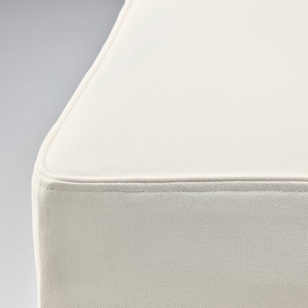 Coin de chaise rembourré blanc épuré et moderne avec revêtement en tissu lisse et amovible, mettant en valeur des coutures soignées.