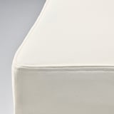 Coin de chaise rembourré blanc épuré et moderne avec revêtement en tissu lisse et amovible, mettant en valeur des coutures soignées.