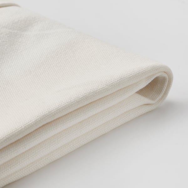 Tissu en coton blanc plié sur une surface blanche. Le tissu semble lisse, tissé et propre.