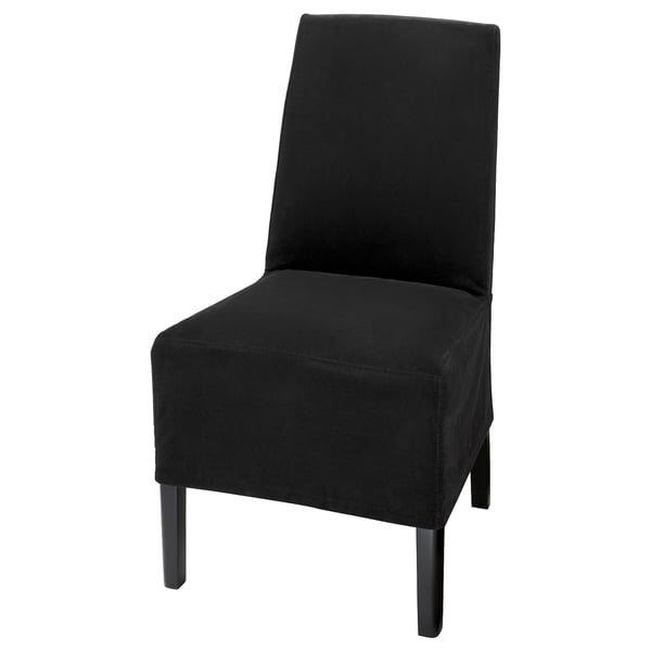 Chaise en velours noir, faisant partie de la série BERGMUND, dotée d’un design élégant et sans dossier avec des pieds en métal. Confortable avec housse amovible et lavable.