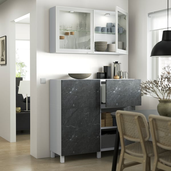 Cuisine moderne avec armoire en marbre foncé, portes vitrées et pieds en métal élégants.