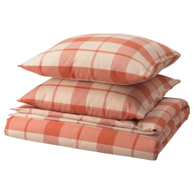 Une pile de linge de lit BESKSÖTEMAL en flanelle à carreaux rouge-brun avec deux oreillers et une housse de couette pliée.