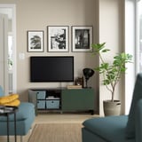 Salon moderne avec banc TV BESTÅ, étagères réglables, télévision à écran plat et décoration.