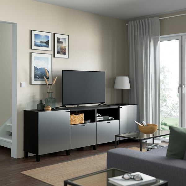 Salon moderne avec banc TV BESTÅ, écran plat et décoration en noir et blanc.