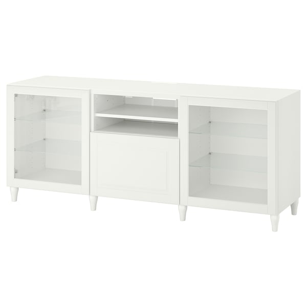 Meuble TV BESTÅ blanc avec portes en verre, étagères réglables et design minimaliste.