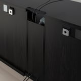 Meuble TV noir avec sortie de câble, tiroir à fermeture douce et support de fixation murale.