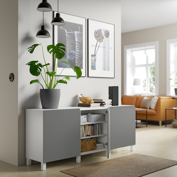 Unité de rangement moderne avec étagères ouvertes et armoire, exposant des livres et des objets décoratifs à côté du salon.