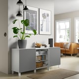 Unité de rangement moderne avec étagères ouvertes et armoire, exposant des livres et des objets décoratifs à côté du salon.