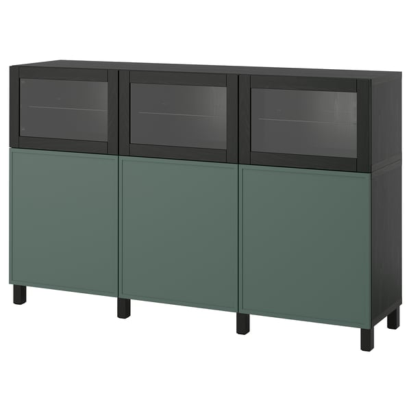 Un buffet ikea BESTÅ aux couleurs vertes et sombres. Il a des portes vitrées et des portes pleines, avec des étagères réglables à l’intérieur.
