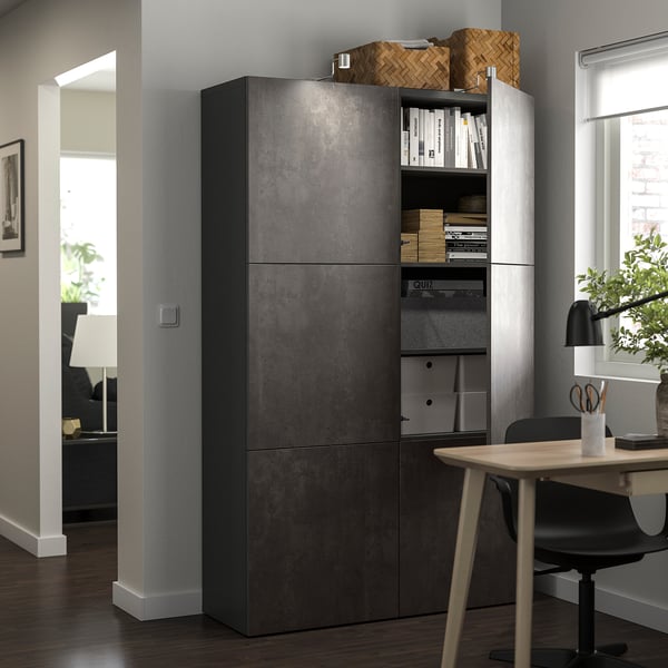 Bureau à domicile moderne avec une grande unité de rangement sombre, des étagères ouvertes avec des livres, des paniers et un bureau avec lampe.