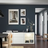 Salle à manger moderne avec buffet BESTÅ, verrerie, assiettes. Art minimaliste, parquet sombre, meubles clairs.