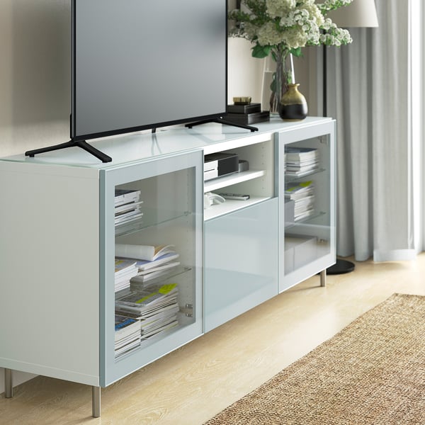 Salon moderne avec télévision, livres et fleurs.