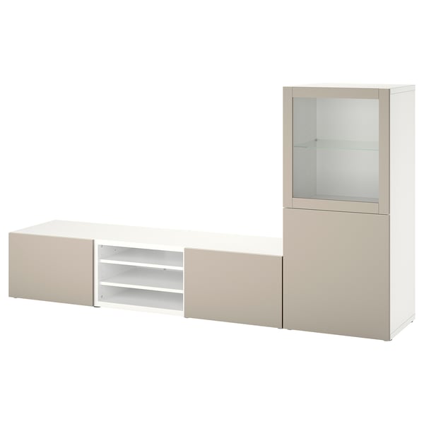 Un meuble de rangement TV BESTÅ en blanc et beige. Il s’agit d’un banc TV bas, d’une armoire haute et d’une étagère ouverte, disposés pour un stockage multimédia optimal.